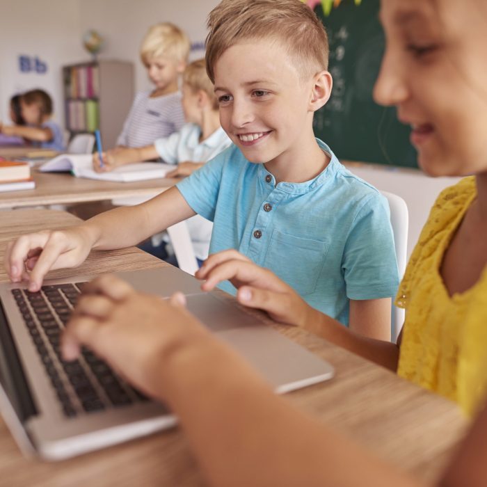 Two kids using laptop during lesson